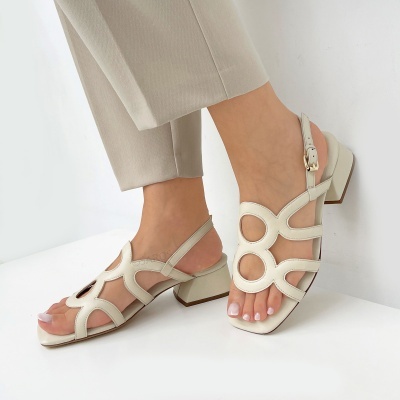 Sandálias de couro bege claro com salto médio e padrão circular recortado