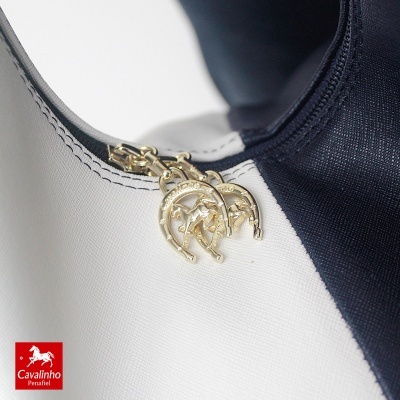 Peça de vestuário branco e azul escuro com pingentes dourados em forma de ferradura