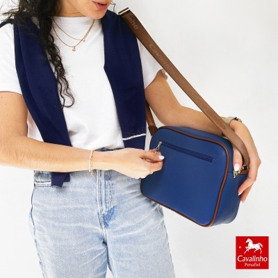 Mala azul com contornos castanhos e alça castanha com o texto Cavalinho