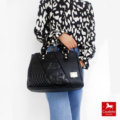 Mala preta em pele com texturas variadas e placa metálica da marca Cavalinho