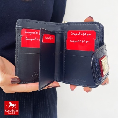 Carteira azul escura em pele com textura de crocodilo e aba com placa metálica dourada