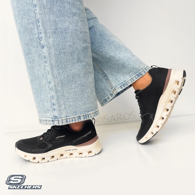 Skechers desportivo preto com sola branca e detalhes castanhos, usado com calças de ganga claras
