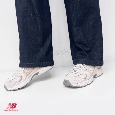 Sapatilhas New Balance brancas e rosa com calças de ganga azuis escuras