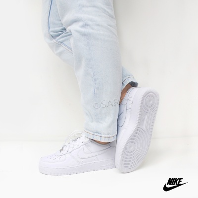 Ténis Nike Air Force 1 brancos com sola branca usados com calças de ganga claras