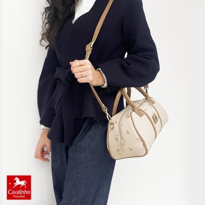 Bolsa de mão bege com padrão de cavalos e ferraduras e alça castanha