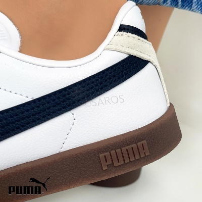 Sapatilha branca Puma com risca preta e sola castanha em destaque