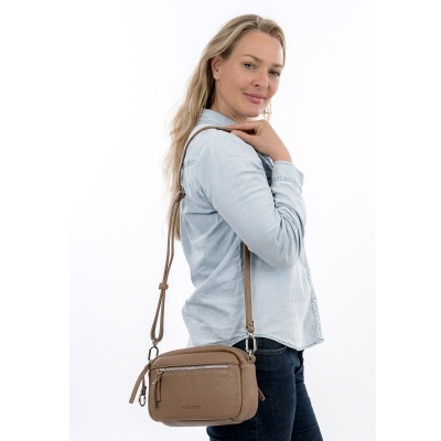 Mulher loira com camisa azul clara e mala castanha ao ombro