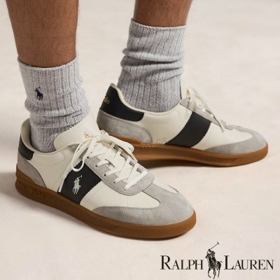 Sapatilhas Ralph Lauren cinza, branco e preto com sola castanha, usadas com meias cinzentas.