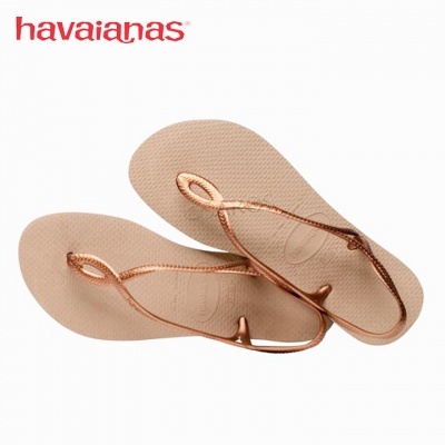 Chinelos Havaianas bege com tiras bronze metálico junto ao logo vermelho