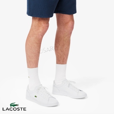 Ténis brancos Lacoste com logo de crocodilo verde e meias brancas