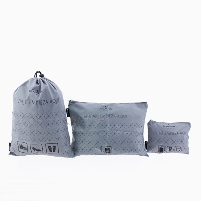 Conjunto de três bolsas de tecido cinzento claro com padrão geométrico e texto EL VIAJE EMPIEZA AQUÍ