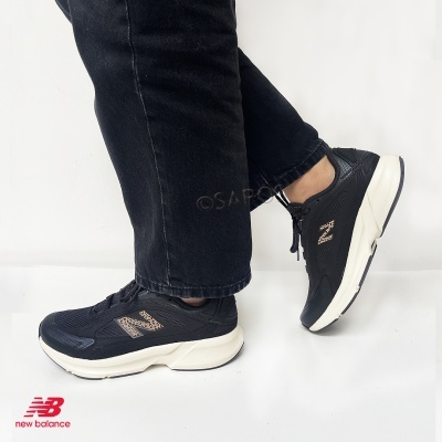 Ténis New Balance pretos com sola branca e logo bege em fundo branco