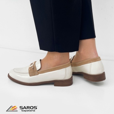 Sapatos mocassin creme com detalhes castanhos usados com calças pretas