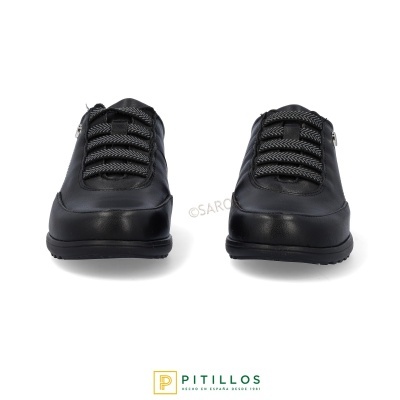 Ténis pretos com atacadores grossos cinzentos e pretos vistos de frente