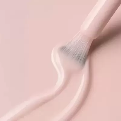 Pincel de maquilhagem com produto líquido rosa claro