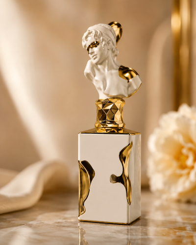Frasco de perfume branco com detalhes dourados e tampa com busto clássico dourado