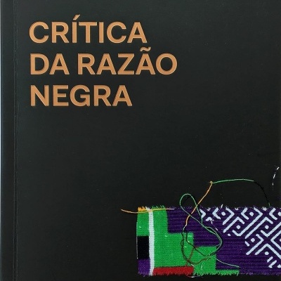 Capa de livro preta com título e autor em letras castanhas e faixa de tecido colorido