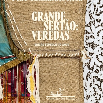 Capa de livro com tecido rústico e aplicações coloridas junto a renda branca