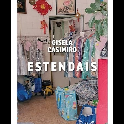 Loja com roupas em cabides protegidas por sacos transparentes e decoração na parede