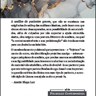 Capa de livro branco com texto em português sobre psicanálise, em cima de superfície marmoreada cinza, preto e dourado