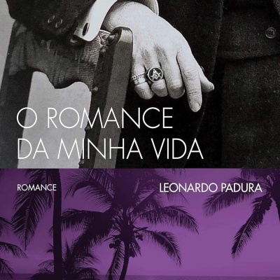 Capa do livro O ROMANCE DA MINHA VIDA com mão masculina e palmeiras à beira-mar em tons roxos