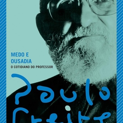 Capa de livro com foto de homem com barba e óculos e texto em azul e preto