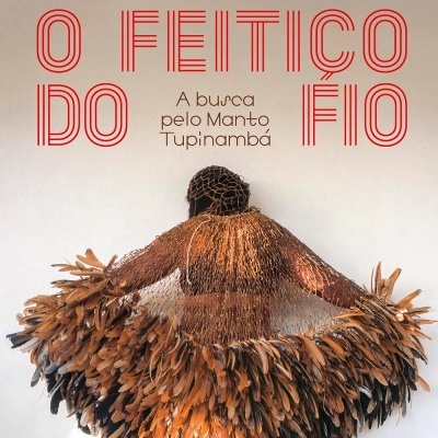 Manto Tupinambá com penas castanhas e pretas sobre uma pessoa vista de costas