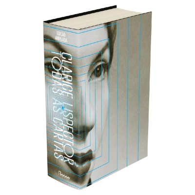 Livro com capa rígida cinzenta com rosto humano e texto branco na lombada
