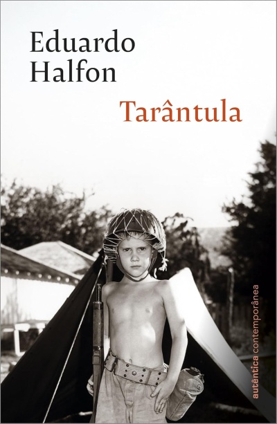 Capa do livro Tarântula de Eduardo Halfon com foto a preto e branco de um rapaz com capacete e tenda ao fundo