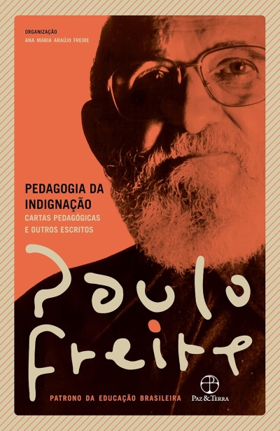 Capa de livro Pedagogia da Indignação com rosto de homem idoso com barba e óculos em fundo laranja.