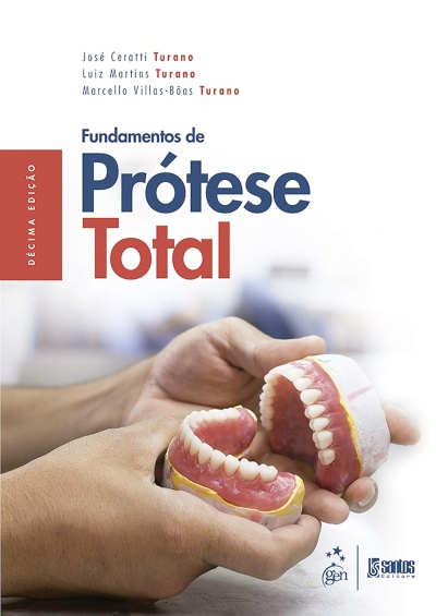 Livro Fundamentos de Prótese Total com próteses dentárias nas mãos
