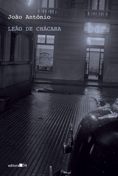 Capa de livro com fotografia noturna a preto e branco de rua e texto editorial
