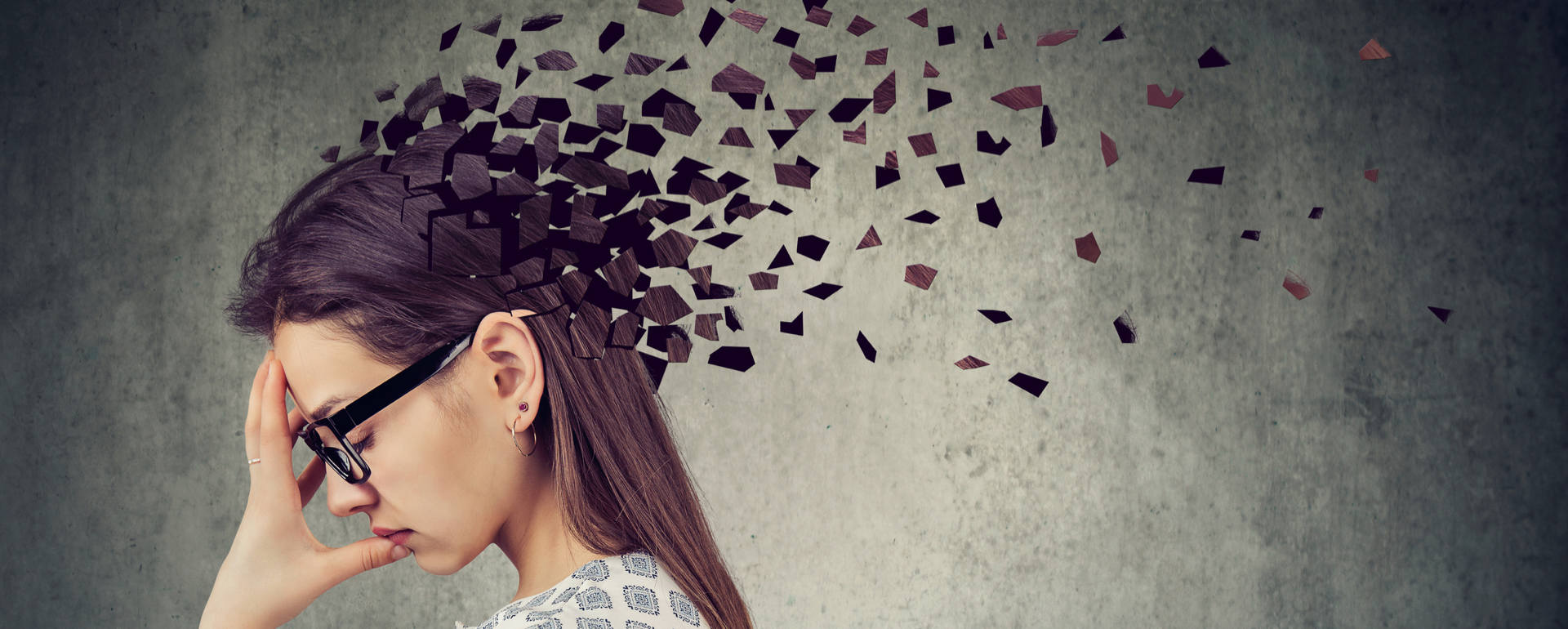 Mulher com óculos e cabelo castanho com efeito visual de dispersão de pequenos pedaços quadrados pretos da cabeça