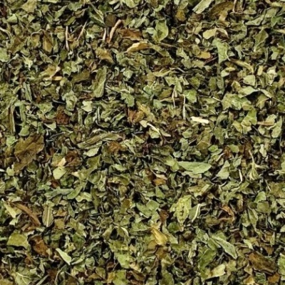 Ervas secas picadas verdes e castanhas, textura irregular, sem embalagem visível