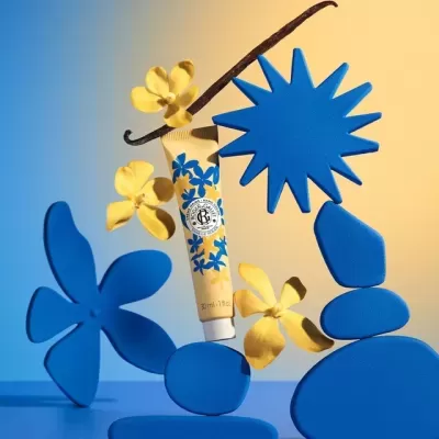 Tubo de creme com estampas azuis, flores amarelas, formas geométricas azuis em fundo azul e bege