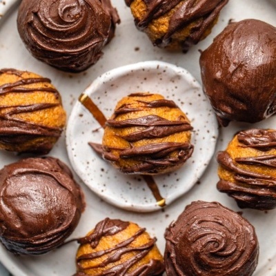 Bolinhos com cobertura e fios de chocolate num prato branco