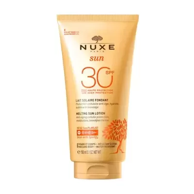 Tubo amarelo dourado de loção solar Nuxe Sun FPS 30 com texto em francês e inglês e padrão de árvore laranja