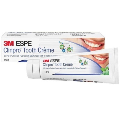 Pasta de dentes 3M ESPE Clinpro Tooth Crème em tubo branco ao lado da sua caixa com imagem de boca sorridente