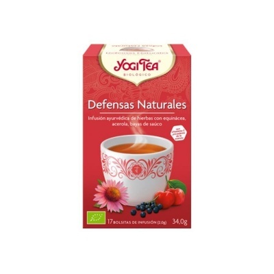 Pacote vermelho de chá Yogi Tea Defensas Naturales com chá numa chávena branca decorada e frutas