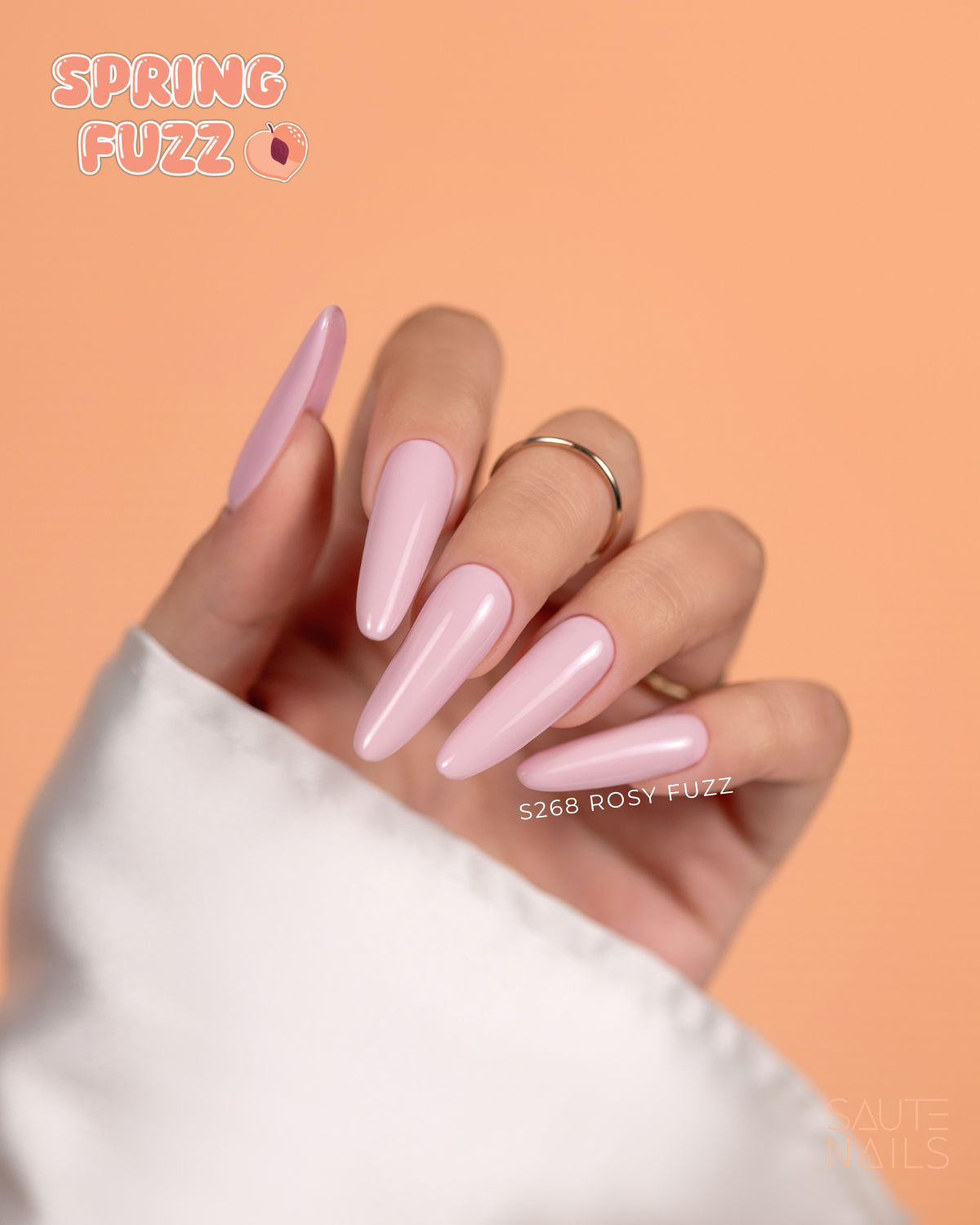 Verniz Gel S268 - Rosy Fuzz (Rosa Primaveril) Mão com unhas stiletto rosa claro em fundo laranja