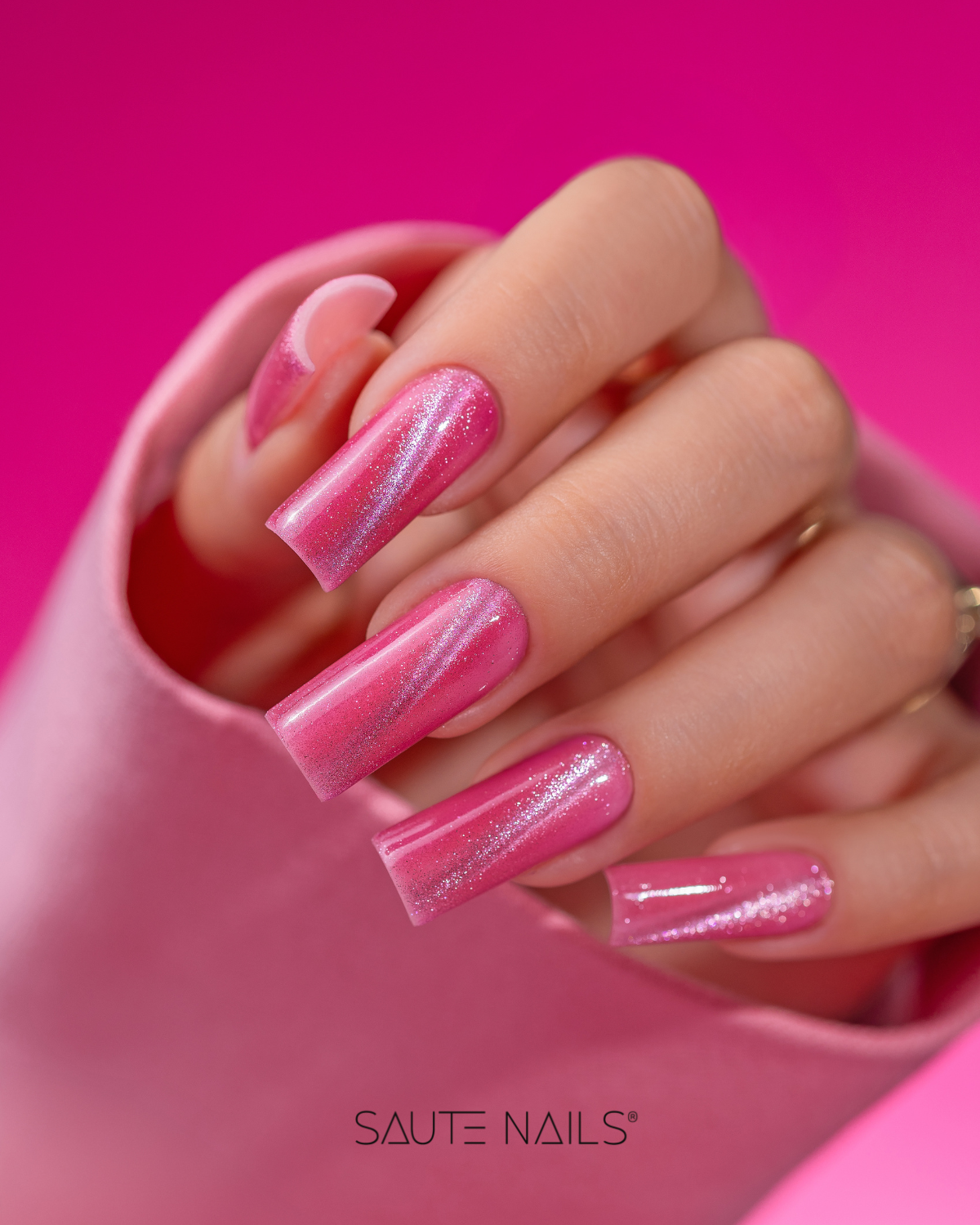 Verniz Gel Cateye Effect E07 (Rosa Claro Cintilante) Unhas artificiais longas rosa com brilho em mão com casaco rosa