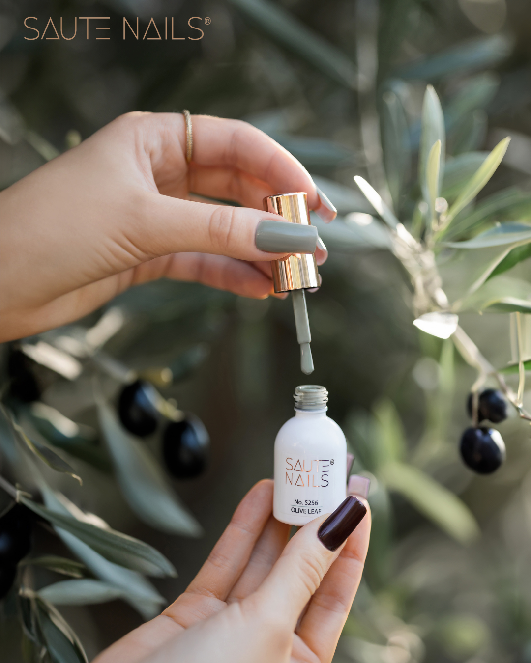 Verniz Gel S256 Olive Leaf (Verde Acinzentado) Frasco aberto de verniz de unhas SAUTE NAILS Green Leaf com mãos segurando