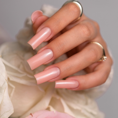 Unhas longas rosa perolado em mão segurando rosas brancas e rosa, com texto SAUTE NAILS®