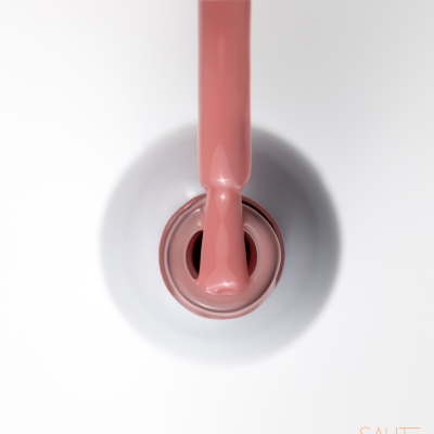 Verniz das unhas rosa claro aberto com pincel a sair da garrafa branca