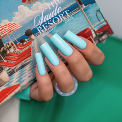 Unhas longas azuis claras a segurar catálogo do Saute Resort