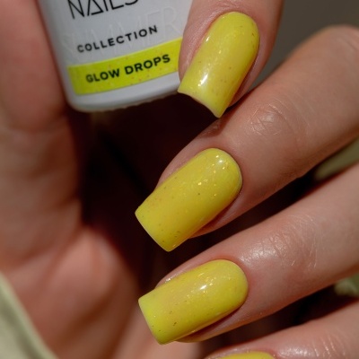 Unhas pintadas de amarelo com verniz brilhante e frasco de esmalte SAUTE NAILS GLOW DROPS.