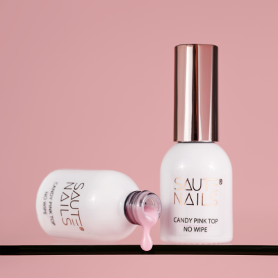 Duas garrafas de verniz para unhas SAUTE NAILS com verniz cor-de-rosa sobre fundo rosa.