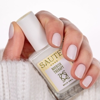 Mão segurando verniz de unhas branco SAUTE CARE