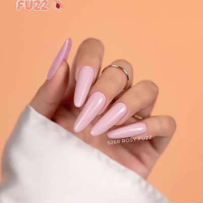 Mão com unhas stiletto rosa claro em fundo laranja