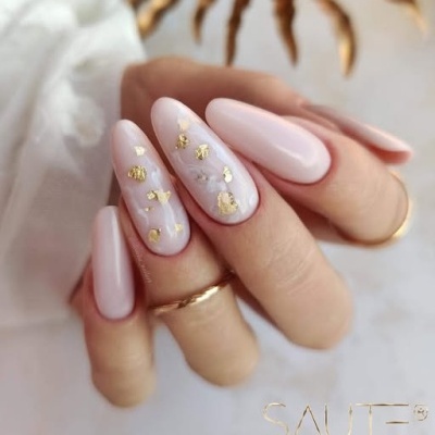 Unhas artificiais cor de rosa translúcido com folha de ouro e anéis dourados